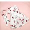 White dress with cherry pattern and bow.
